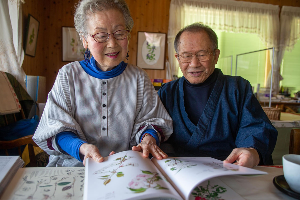 尊敬する太田洋愛氏の画集を見せてくれた杉崎ご夫妻。今も太田氏の絵に近づきたいとの思いで筆をとっています