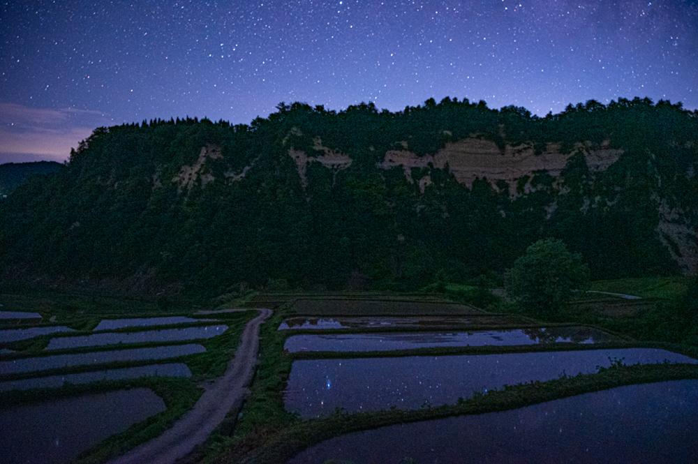 夜明け前。満天の星々が棚田の水面に映る