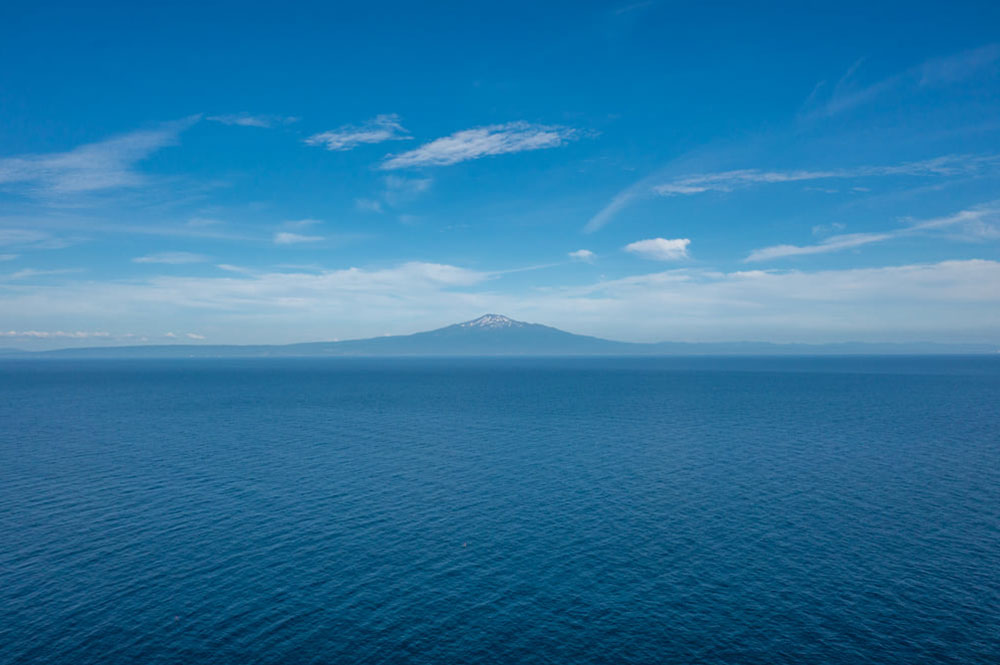 日本海にポッカリと浮かぶ「鳥海山」。左右対称のシルエットが美しい
