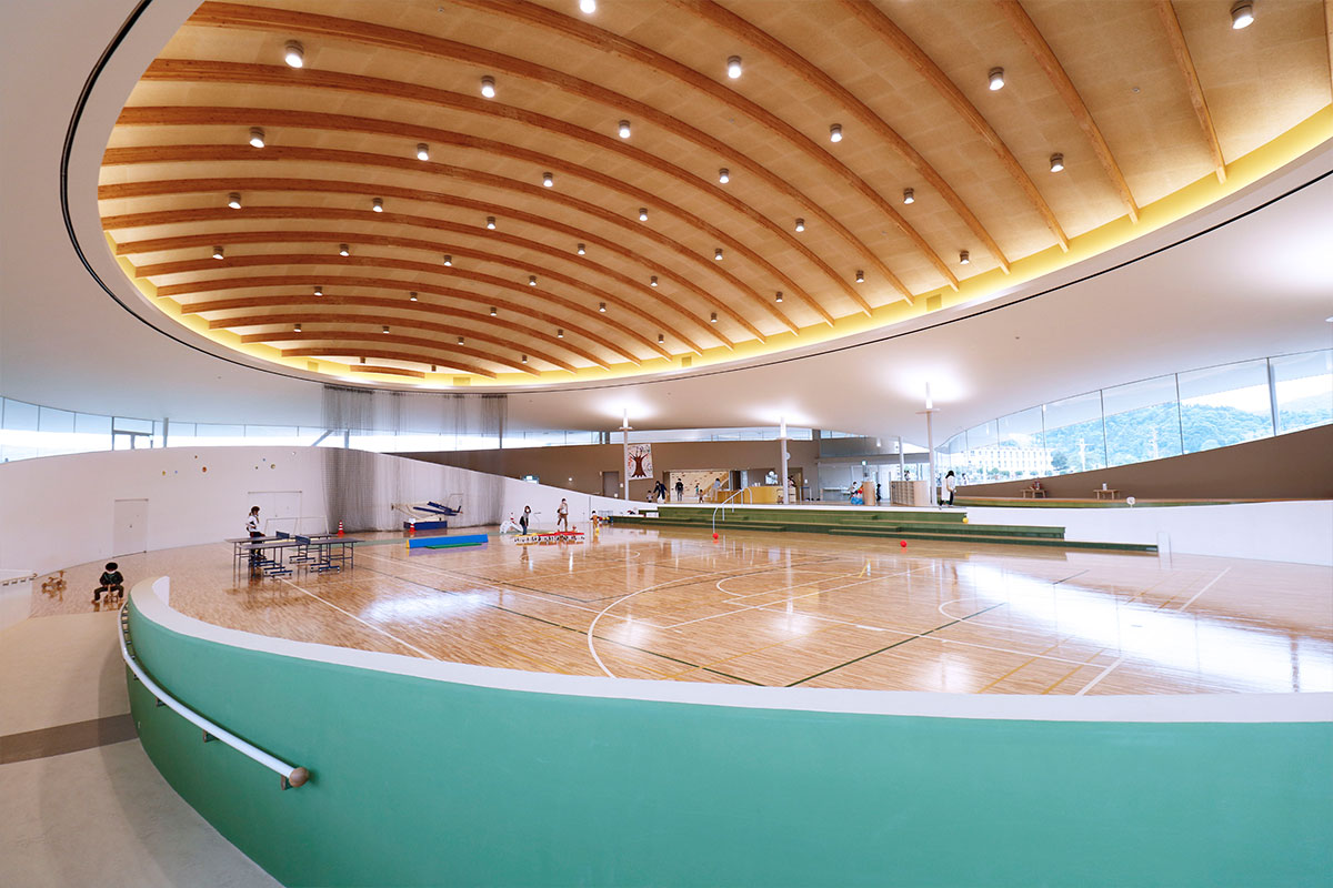 体育館は木造ドームの広々とした空間。スロープの向こうは大型遊戯場につながっている構造に