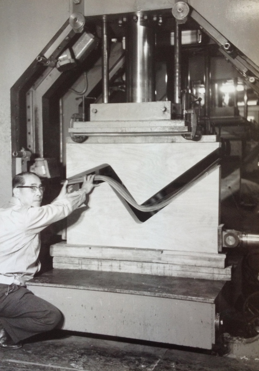 初期の成形合板のプレス機と、天童木工の成形合板技術を導いた乾三郎氏（写真提供：天童木工）
