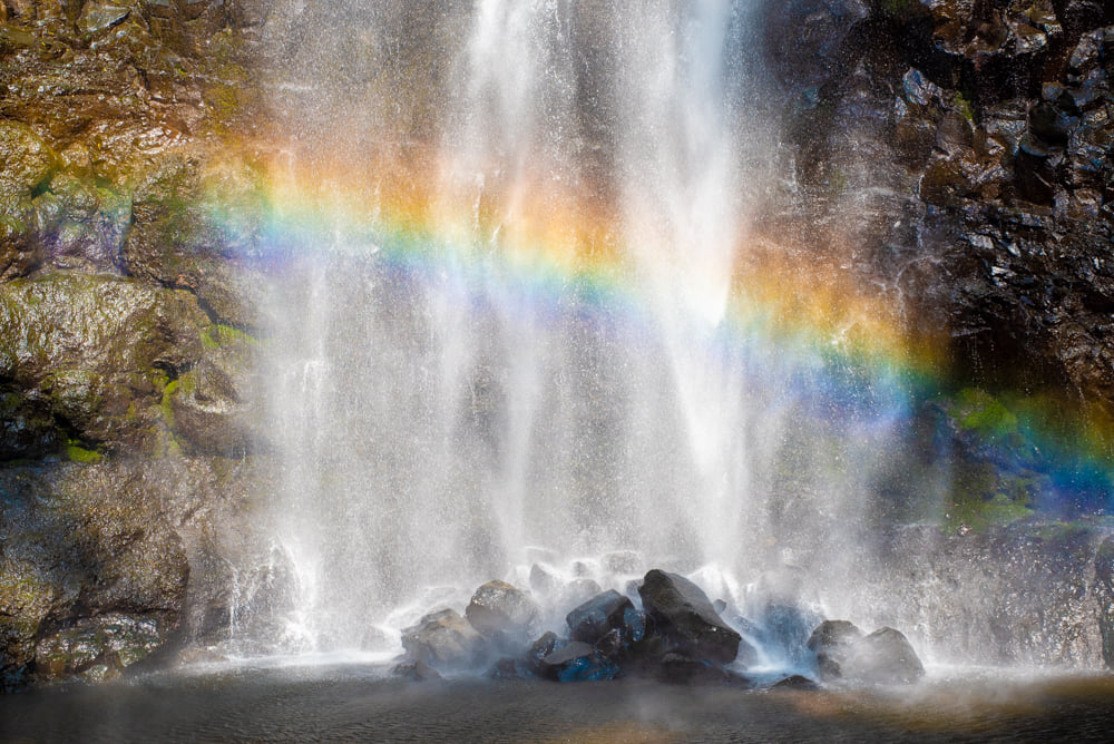 水けむりの滝壺に立つ虹