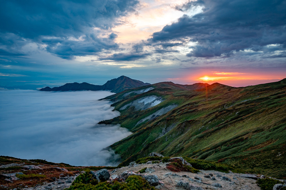 雲海と残雪と夕日が山上の絶景を演出する