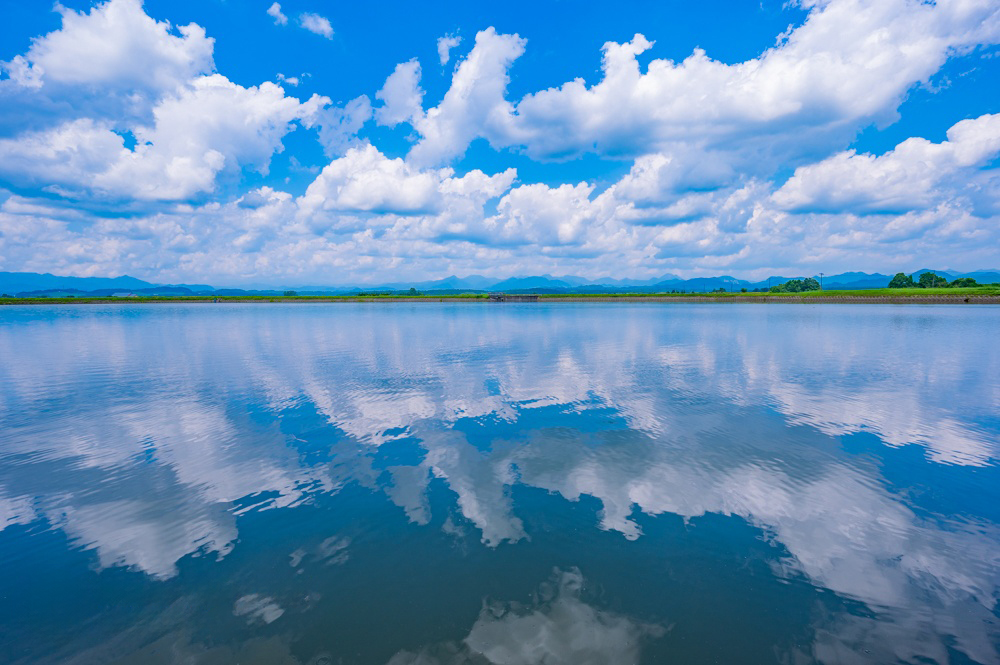 夏場。青空と雲が水鏡に映る美しい風景に出会える